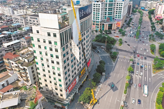 由于要拆除的廣告牌在樓頂，工作人員動(dòng)用75米高的吊機(jī)進(jìn)行作業(yè)。