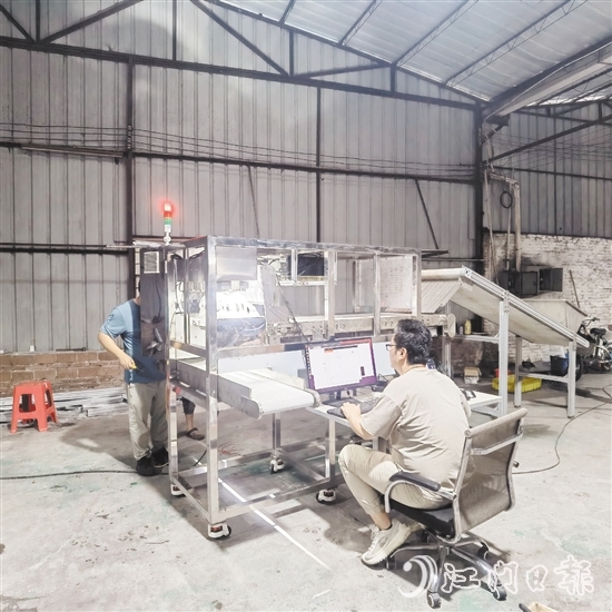 鷹視光電工作人員正在對AI視覺檢測設(shè)備進(jìn)行調(diào)試。