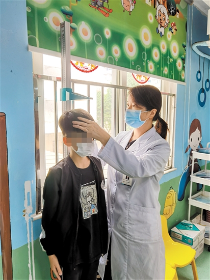 醫(yī)生為兒童量身高。