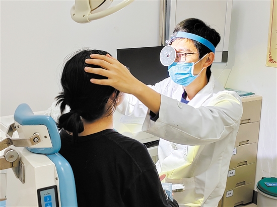 醫(yī)生為患者檢查鼻子。