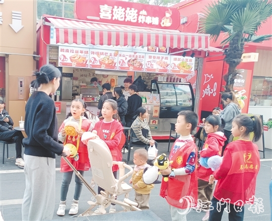 統(tǒng)一身著志愿者服裝的孩子們化身“愛心小掌柜”，向顧客推銷商品。