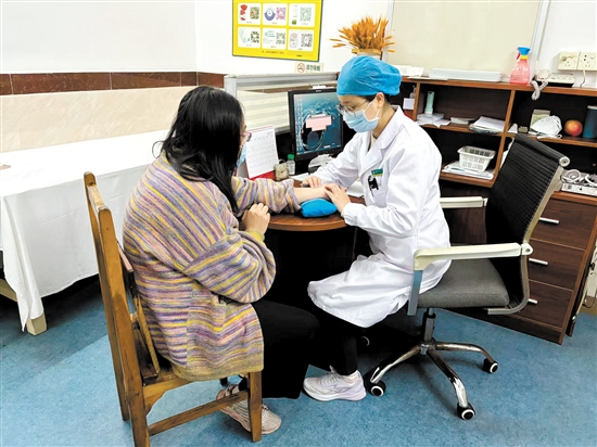 周春華向患者了解情況。