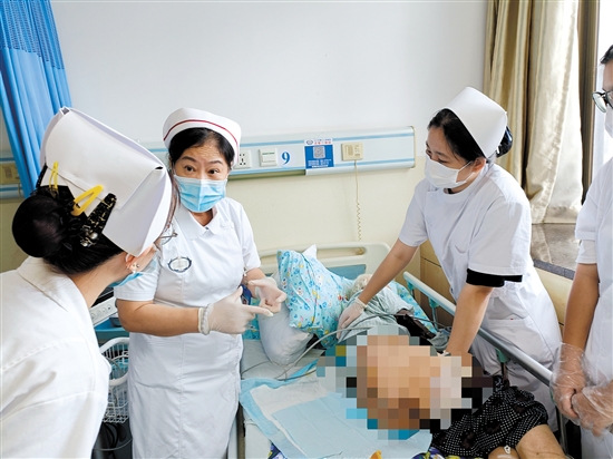 朱敏林（中）與同事對患者進(jìn)行護(hù)理服務(wù)。