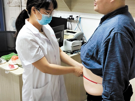 醫(yī)生為記者測(cè)量腰圍。