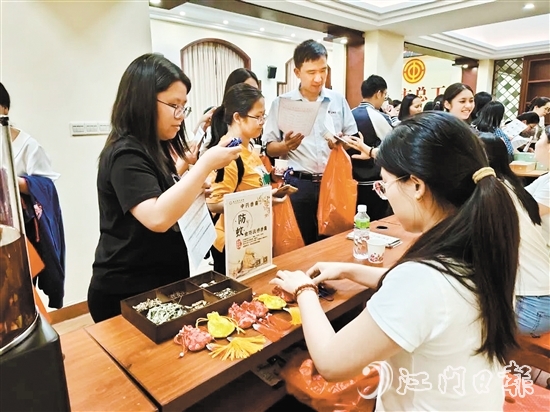 職工們與醫(yī)生探討中藥的成分和比例，制作防感驅(qū)蚊中藥香囊。