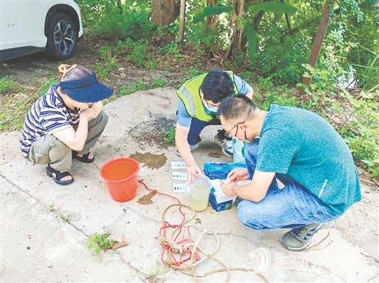 巡河過程中，工作人員沿河查看并采集水樣進行檢測。
