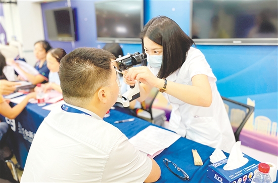 醫(yī)護人員為企業(yè)職工檢查眼睛。