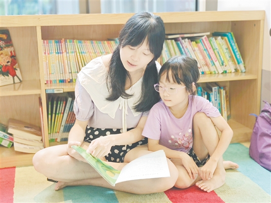 在龍溪湖閱讀中心，一位家長正陪伴孩子讀繪本。