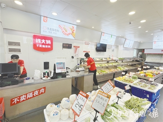 錢(qián)大媽生鮮店的工作人員正在線上接單并準(zhǔn)備菜品。