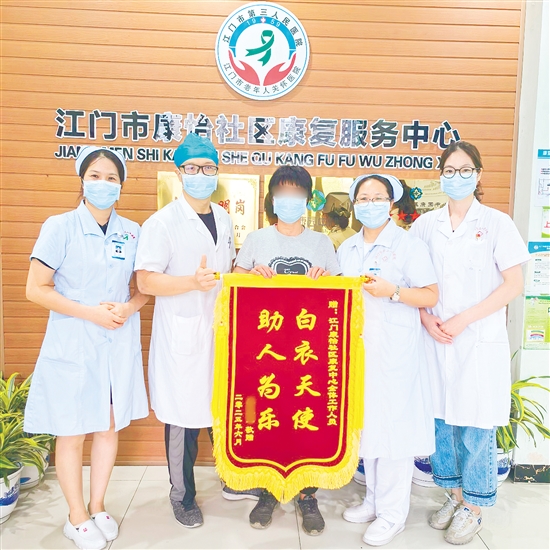 李明給康復(fù)中心醫(yī)護(hù)人員送上錦旗。