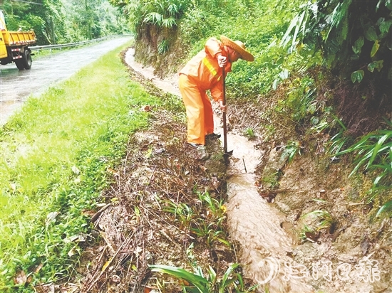 道路養(yǎng)護(hù)人員清理被泥沙落葉堵塞的邊溝涵洞，確保雨水快速排走。