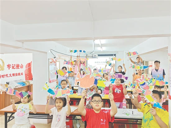 孩子們手持自制荷塘紗龍一起合照，課堂變民俗小舞臺(tái)。