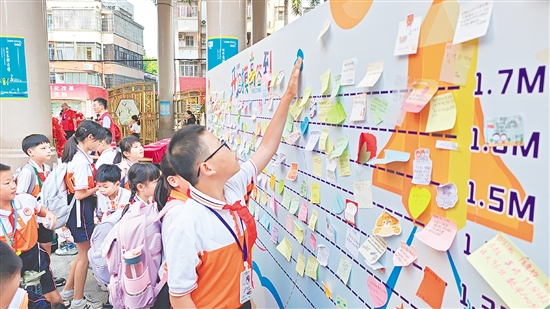 沙坪街道第一小學(xué)設(shè)立“開學(xué)摸高簽到墻”，學(xué)生貼上寫有新學(xué)期愿望的“心愿卡”。