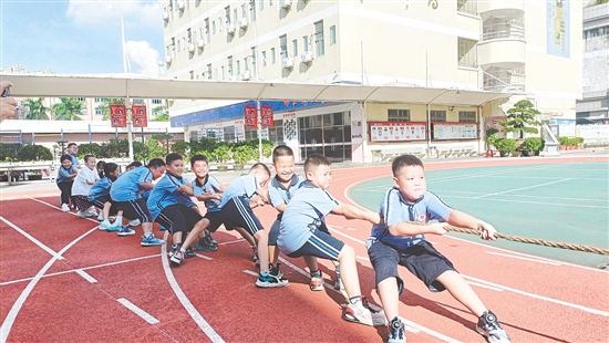 參賽隊(duì)員們緊握長(zhǎng)繩，齊心協(xié)力，鼓足勁拼命往后拉。