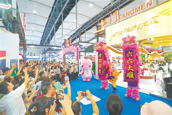 江門展館內(nèi)，醒獅騰躍的精彩表演引得參觀者紛紛舉起手機(jī)，定格這熱鬧瞬間。