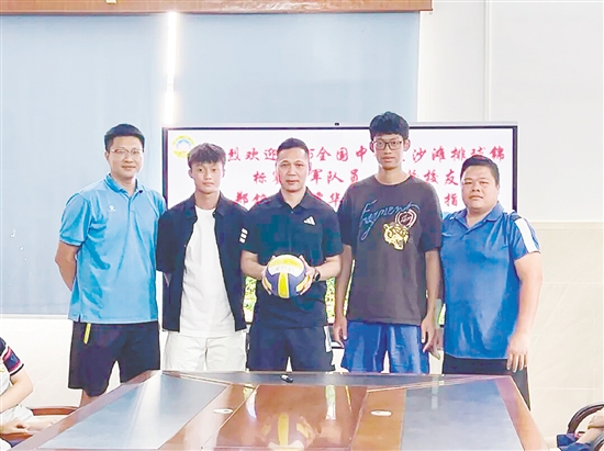 鄭銘毅（左二）與譚華鋒（右二）將親筆簽名的排球贈予母校。