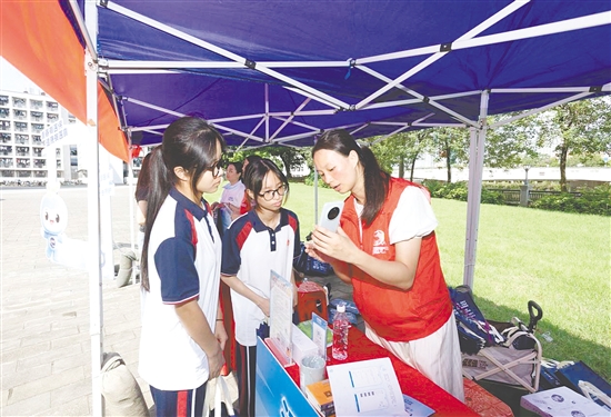 工作人員向新入學學生介紹醫(yī)保線上辦事流程。