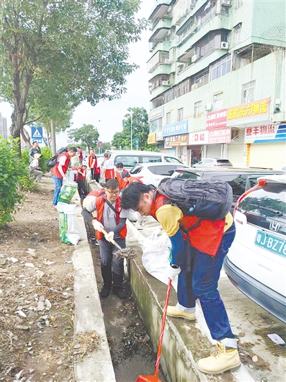 黨員防疫突擊隊(duì)隊(duì)員在開平市長沙街道南島社區(qū)清理垃圾。
