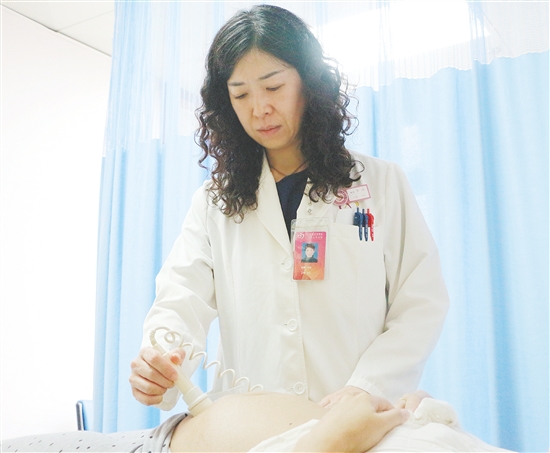 產(chǎn)科醫(yī)生為孕婦檢查胎兒狀況。