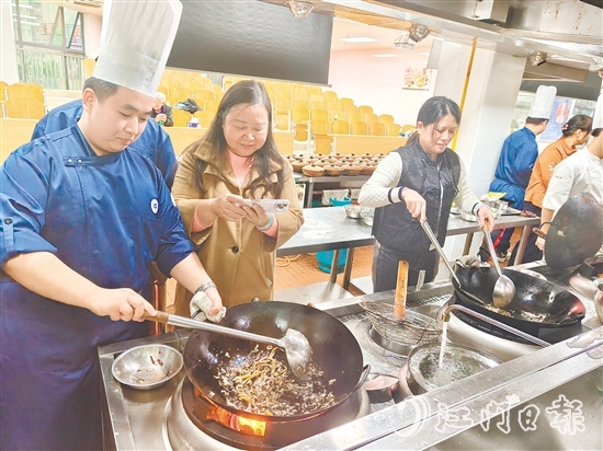 學員們跟著專業(yè)廚師學習制作黃鱔飯。