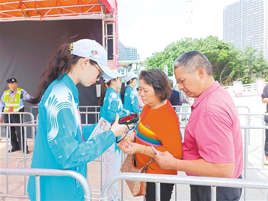 志愿者在場(chǎng)館外為觀眾檢票。