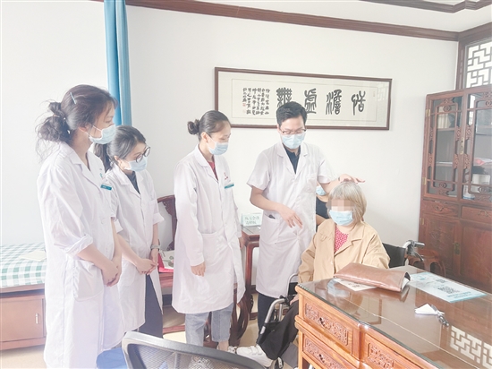 黃任鋒（右二）在中醫(yī)經(jīng)典科門(mén)診開(kāi)展教學(xué)。
