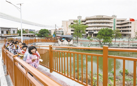 雙橋小學(xué)的學(xué)生放學(xué)后在新修建的步道上結(jié)伴而行，身旁的車(chē)流被欄桿有效隔離，構(gòu)筑起校園交通的安全防線。