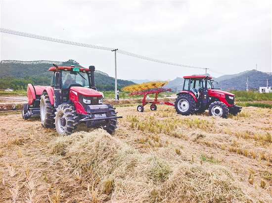 現(xiàn)場展示的新式農機打捆機和摟草機引人注目。