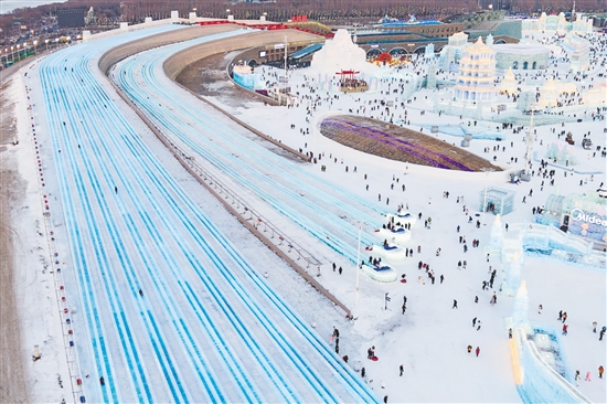 圖為當(dāng)日，游客在哈爾濱冰雪大世界園區(qū)體驗(yàn)“超級(jí)冰滑梯”（無人機(jī)照片）。新華社發(fā)