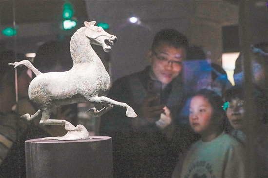 圖為當(dāng)天，在甘肅省博物館二樓絲綢之路文明展廳，觀眾觀看銅奔馬（復(fù)制品）。