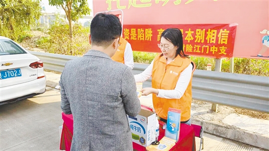 工作人員向過(guò)往司乘人員普及反詐知識(shí)。