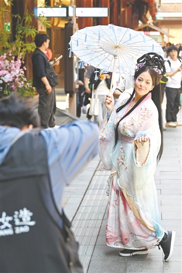 5月5日，外國游客在上海豫園商城內(nèi)體驗古風(fēng)妝造旅拍。新華社發(fā)