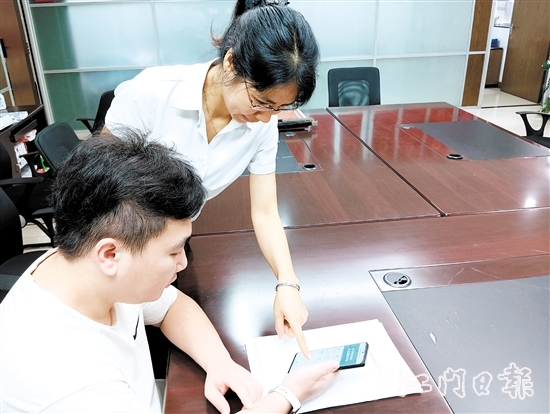 工作人員在指導(dǎo)市民線上交存住宅專項(xiàng)維修資金。陸沿任