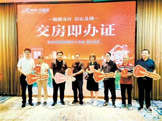 業(yè)主喜拿房產(chǎn)證和鑰匙。